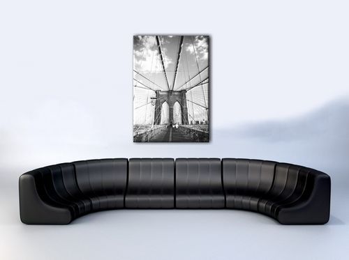 aranżacja obrazu na płótnie z brooklyn bridge w białym pokoju z czarną sofą
