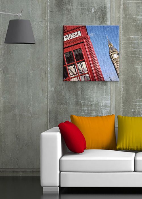 aranżacja obrazu na płótnie z Big Benem i czerwoną budką telefoniczną w pokoju z betonową ścianą nad białą sofą z kolorowymi poduszkami