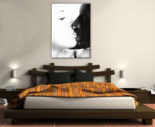 aranżacja obrazu na płótnie przedstawiającego całującą się parę wiszącego w sypialni z szarymi ścianami nad dużym drewnianym łóżkiem