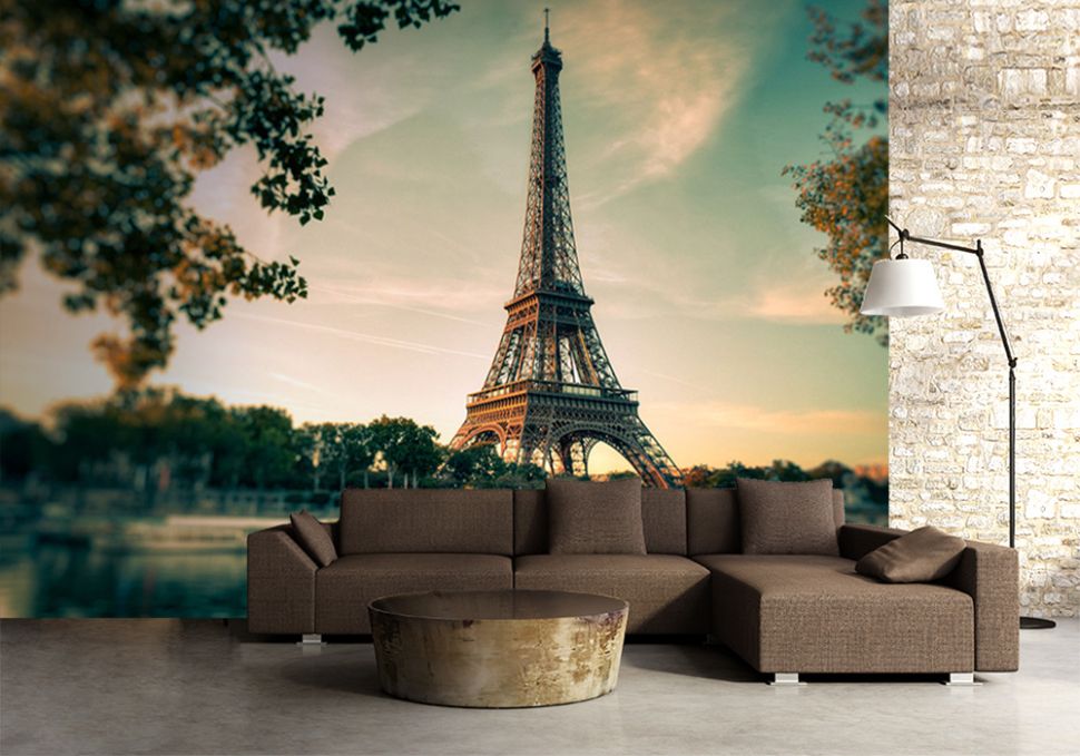 Salon z brązową kanapą za którą na ścianie umieszczona jest ogromna fototapeta z widokiem na wieżę Eiffel