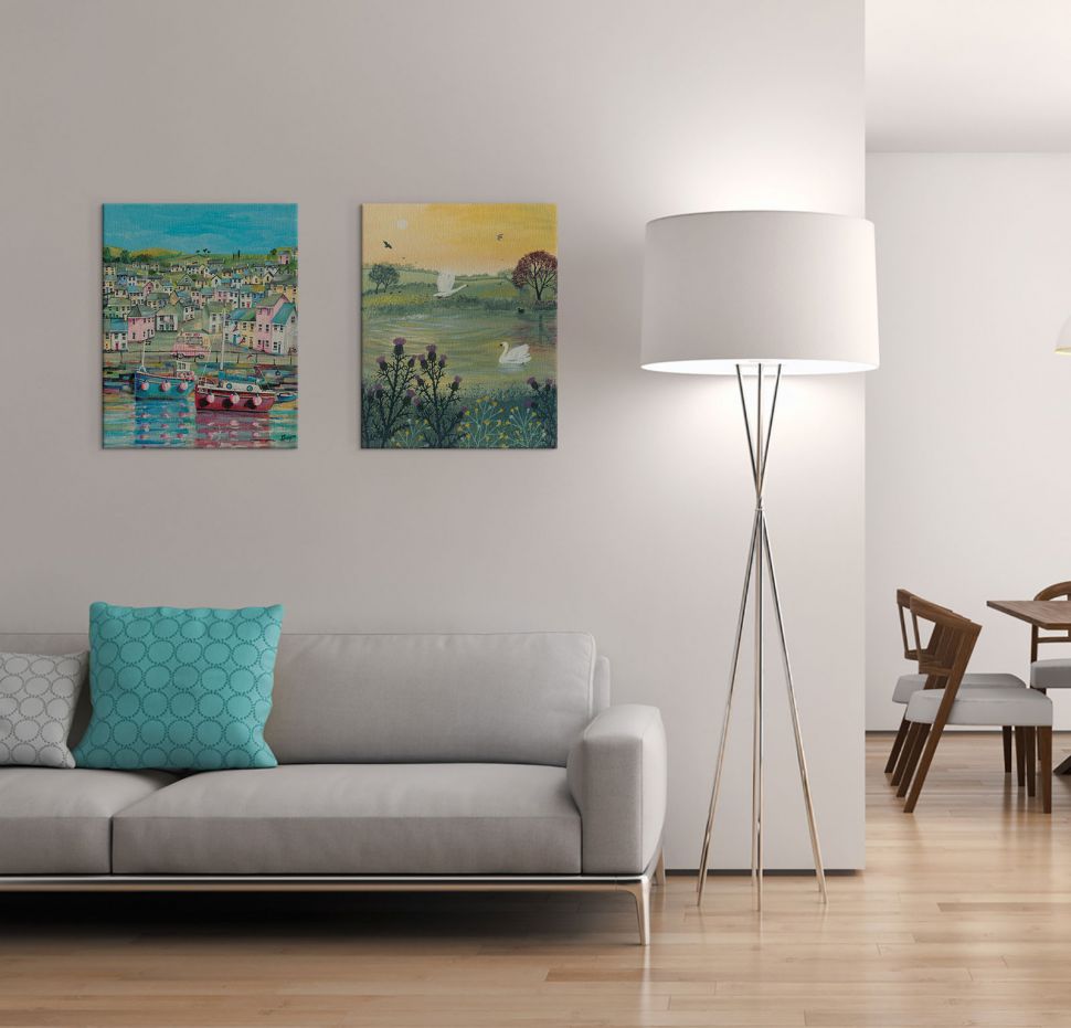 Obraz wiszący w salonie nad kanapą przedstawiający nadmorskie miasteczko i łodzie