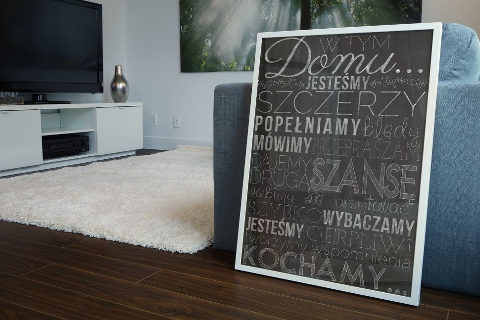 Zasady w Tym Domu - plakat 40x50 cm w białej ramce leżący na podłodze