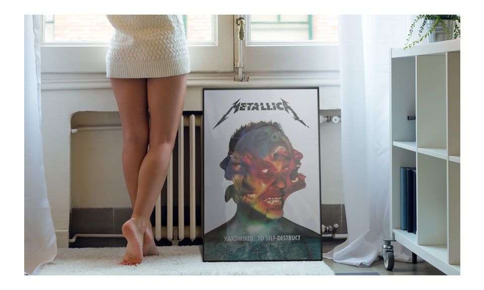 Plakat z albumu Hardwired Metallica oprawiony w czarną ramkę leżącą na podłodze