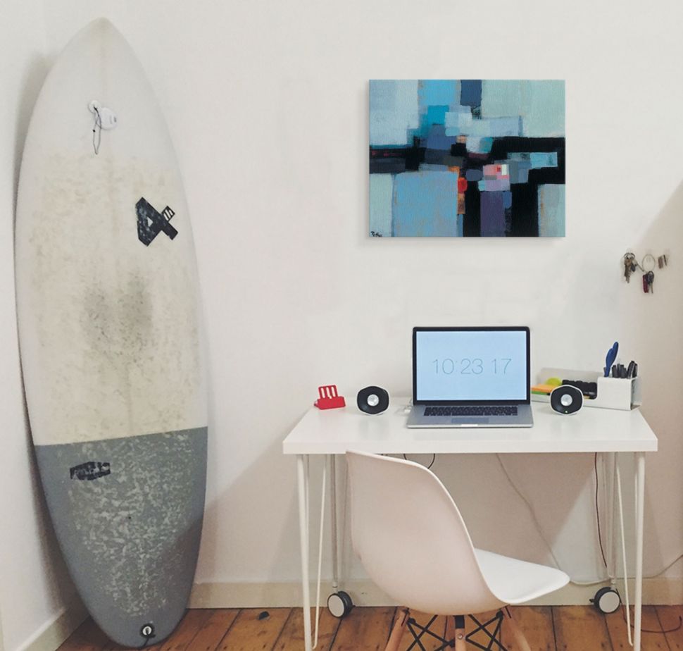 Niebiesko-czarny obraz na płótnie wiszący na białej ścianie nad biurkiem w pokoju