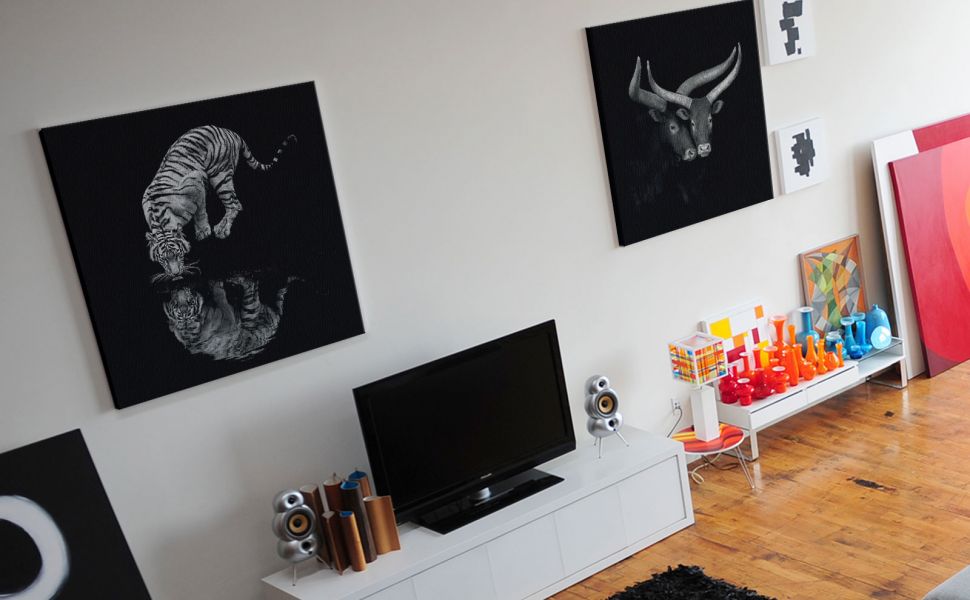 Obrazy na płótnie powieszone w salonie na białej ścianie przedstawiające zwierzęta