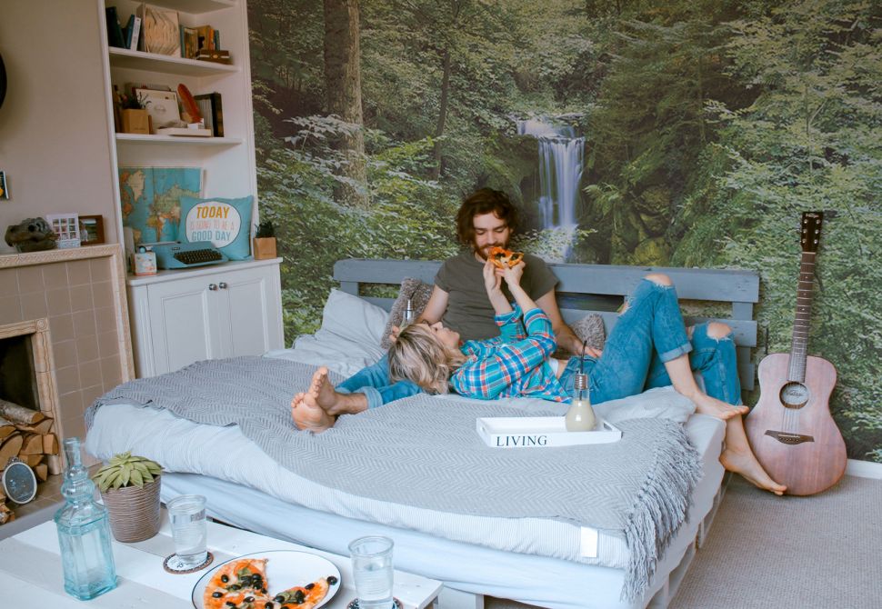 Sypialnia z piękną wiosenną fototapetą z lasem i wodospadem na ścianie
