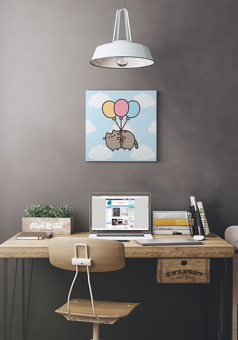 Obraz na płótnie z Pusheen'em i balonami wiszący na szarej ścianie nad drewnianym biurkiem