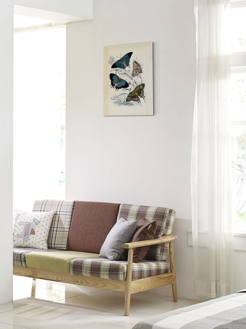 Canvas Butterflies II z motylami wiszący w przedpokoju na białej ścianie nad sofą