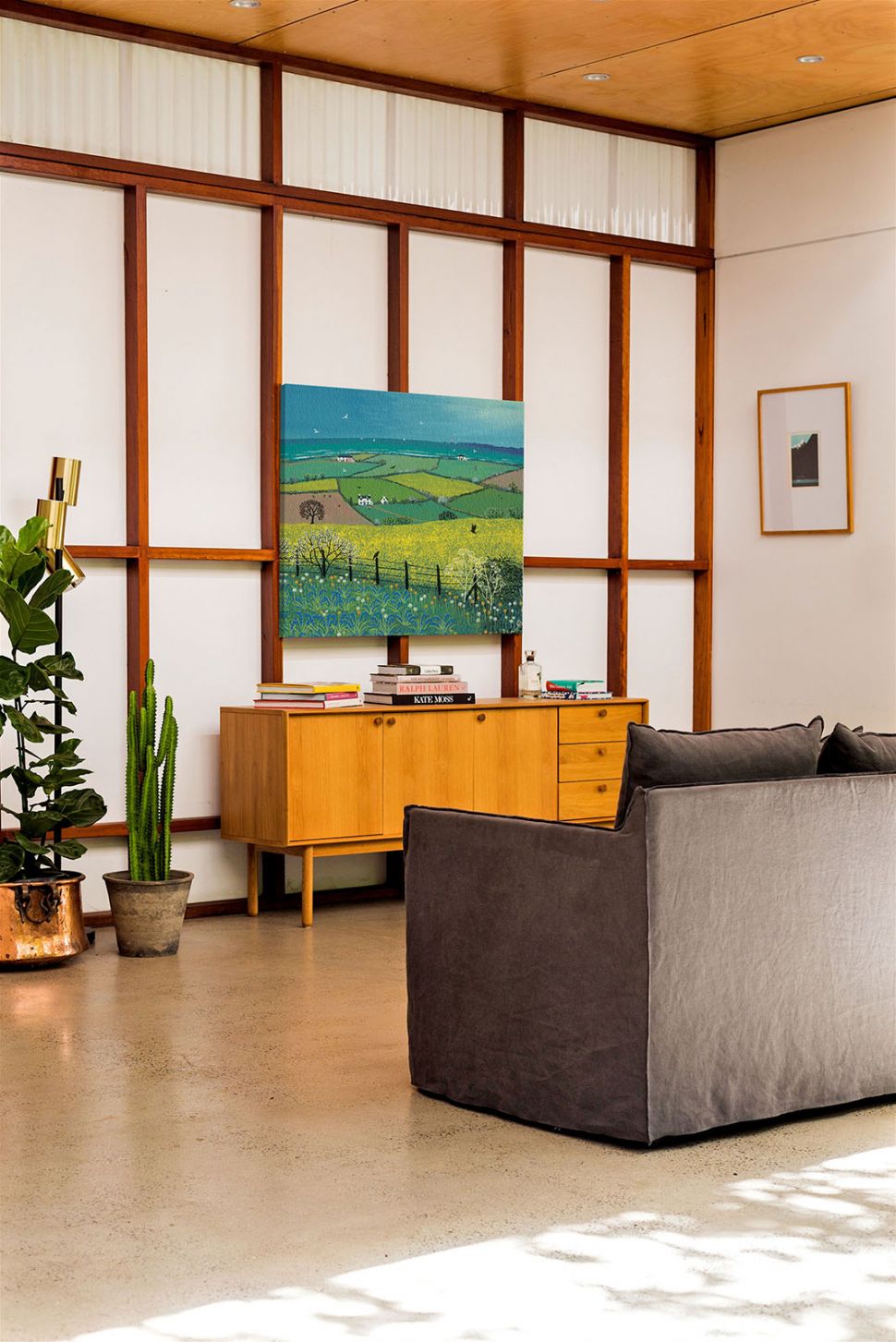 Canvas przedstawiający łąki i pola o nazwie Coastal View wiszący w salonie nad drewnianą szafką