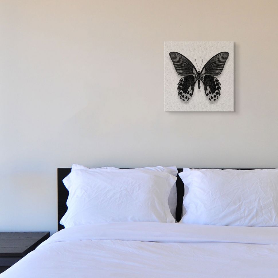 Canvas z czarnym motylem powieszony na ścianie w sypialni