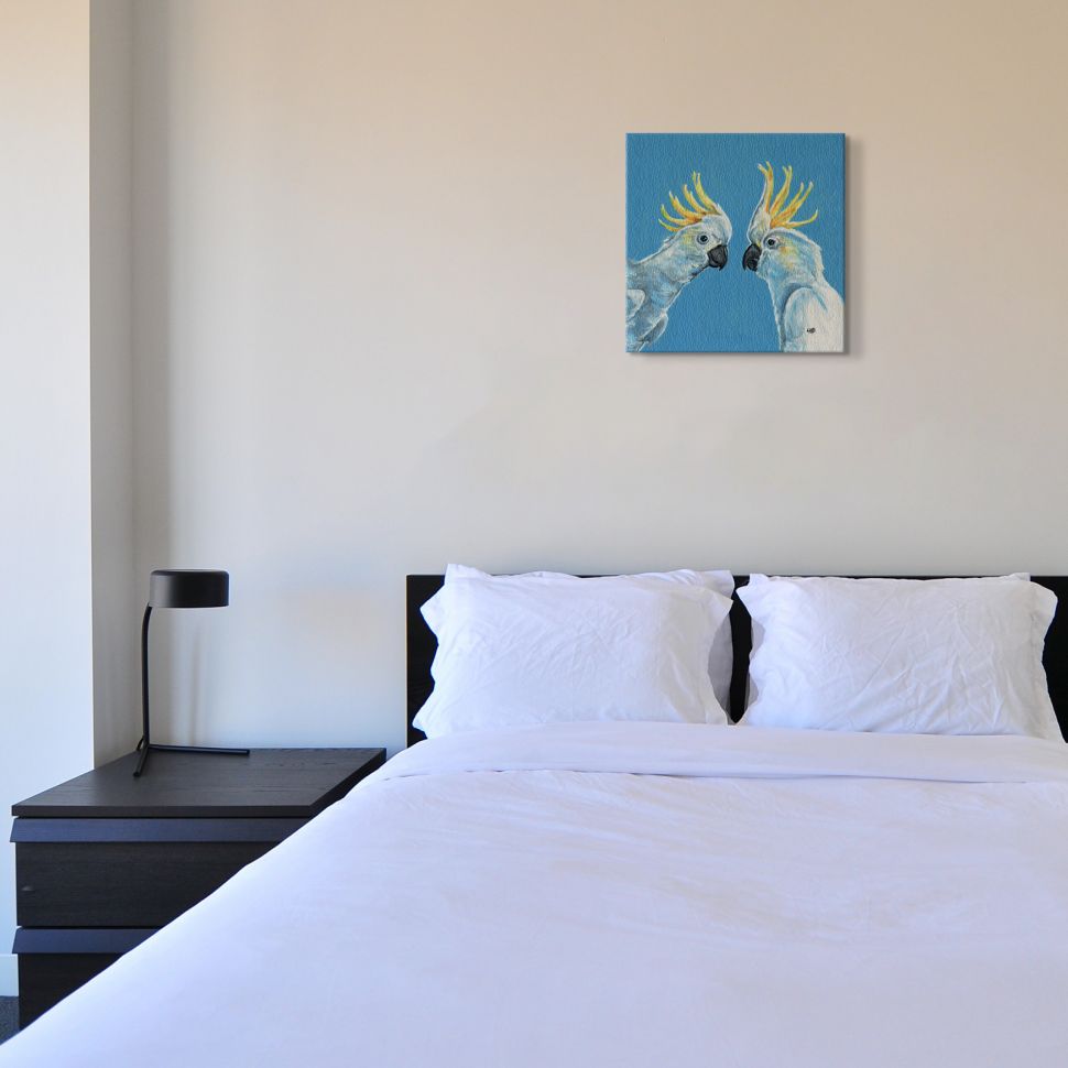 Canvas z dwiema białymi papugami powieszony nad łóżkiem w sypialni
