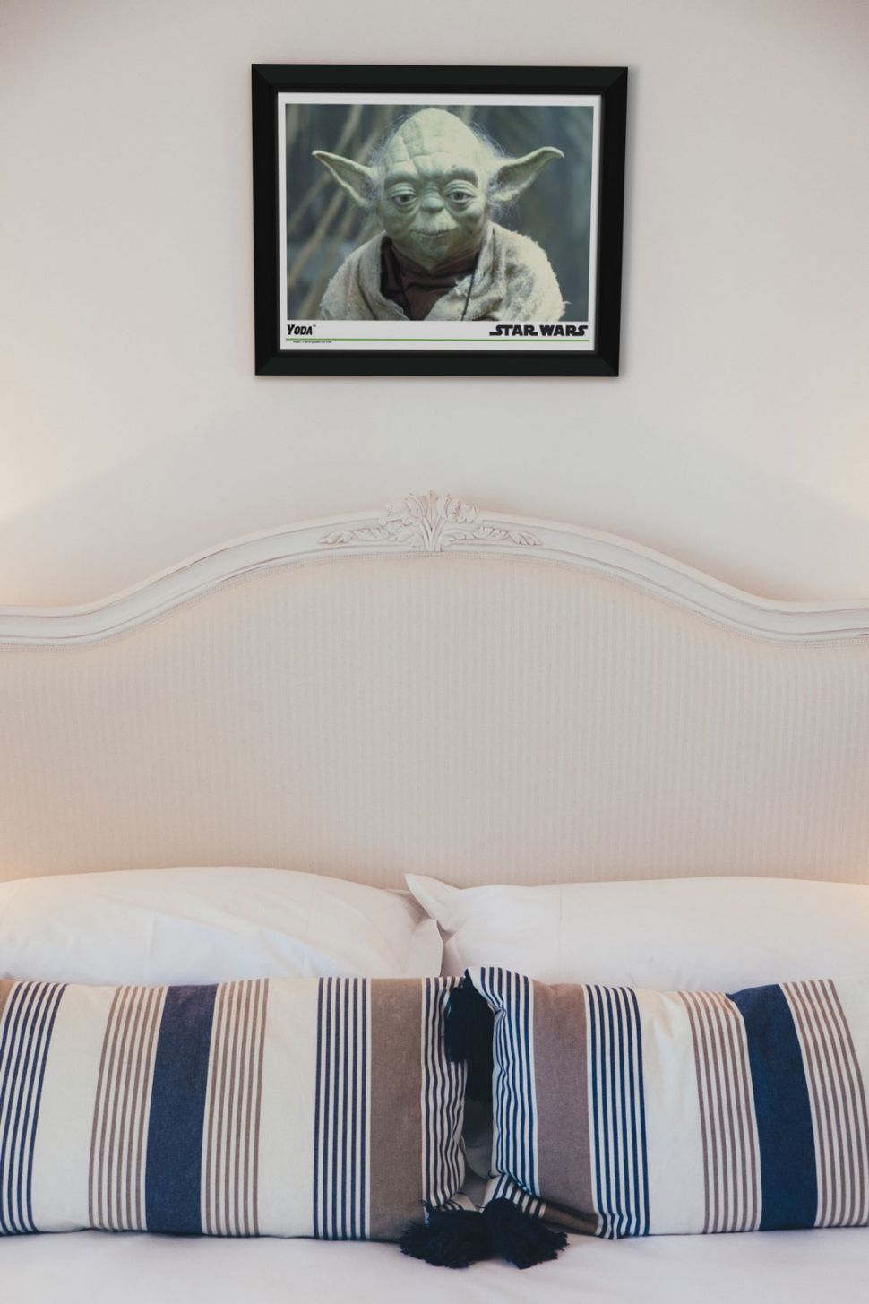 Obraz w ramie z Yodą z Gwiezdnych Wojen powieszony nad łóżkiem