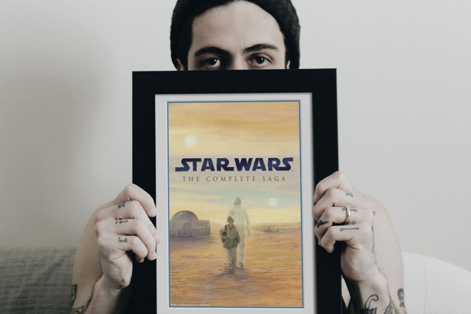Obraz w ramie ze Star Wars trzymany przez mężczyznę