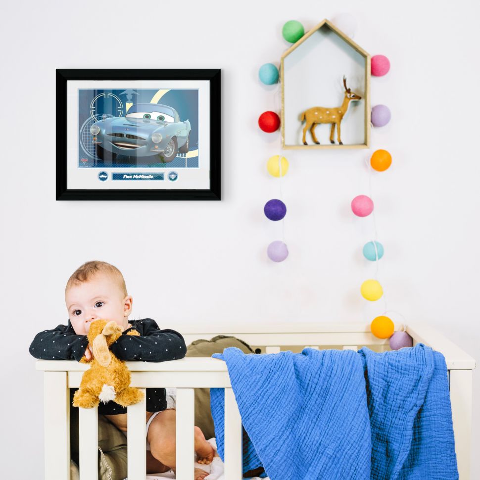 Obraz w ramce z Finnem McMissile z bajki Cars powieszony nad dziecięcym łóżeczkiem