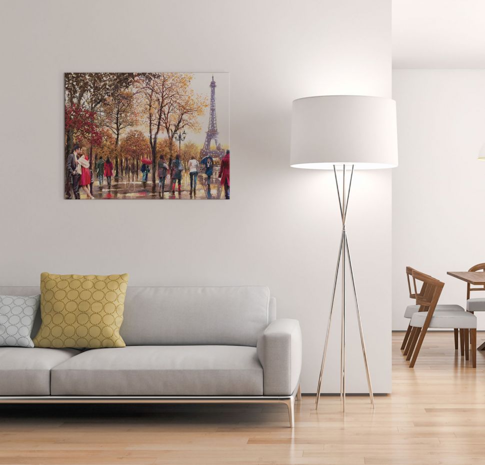 Salon z wiszącym nad szarą sofą canvasem pokazującym Paryż i spacerujących ludzi