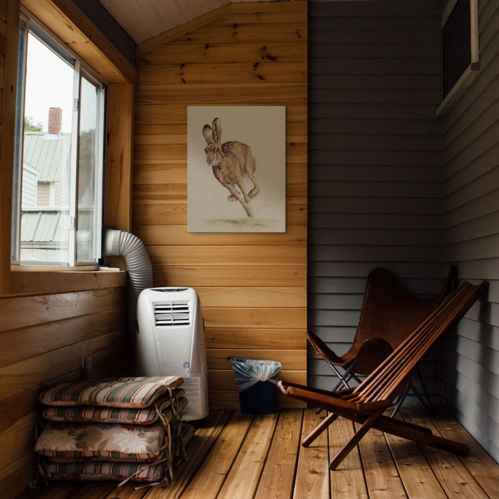 Canvas z zającem autorstwa Jane Bannon powieszony w klimatycznym domku na ścianie z drewna