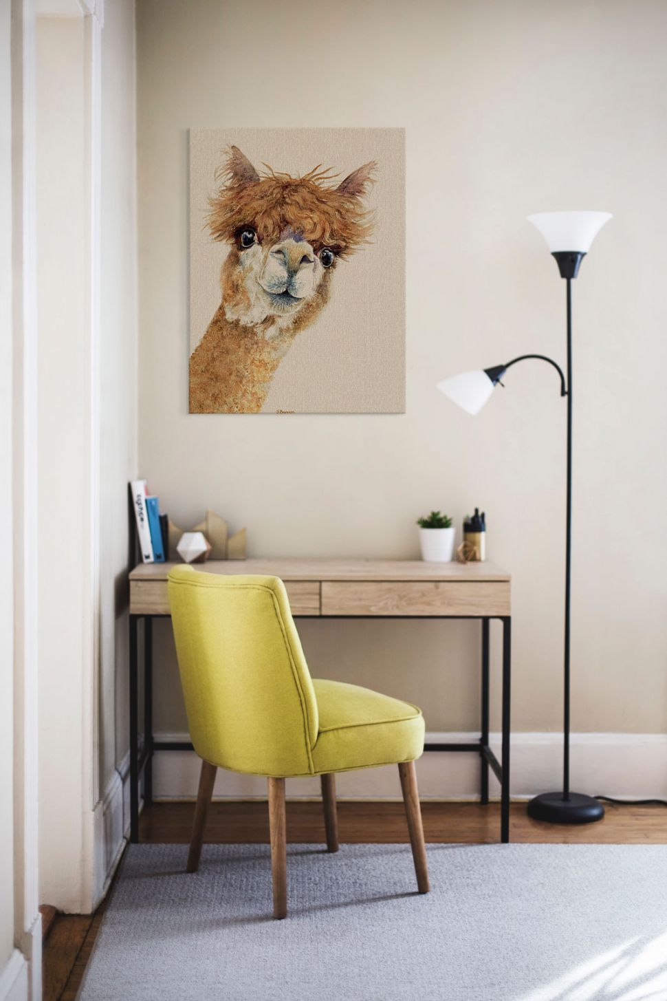 Obraz na płótnie z alpaką powieszony nad drewnianym biurkiem