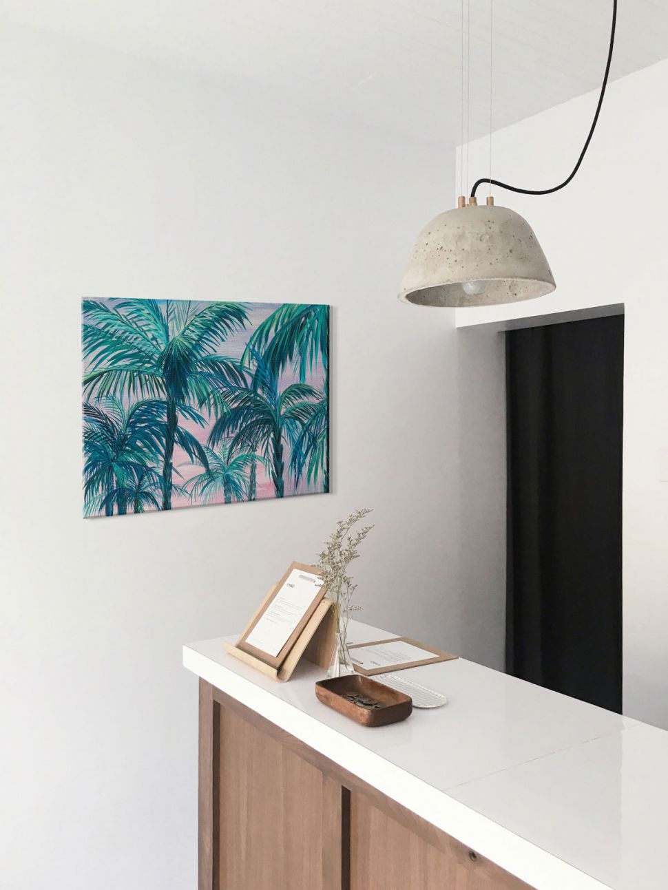 Obraz na płótnie wiszący na białej ścianie w hallu przedstawiający palmy o zachodzie słońca