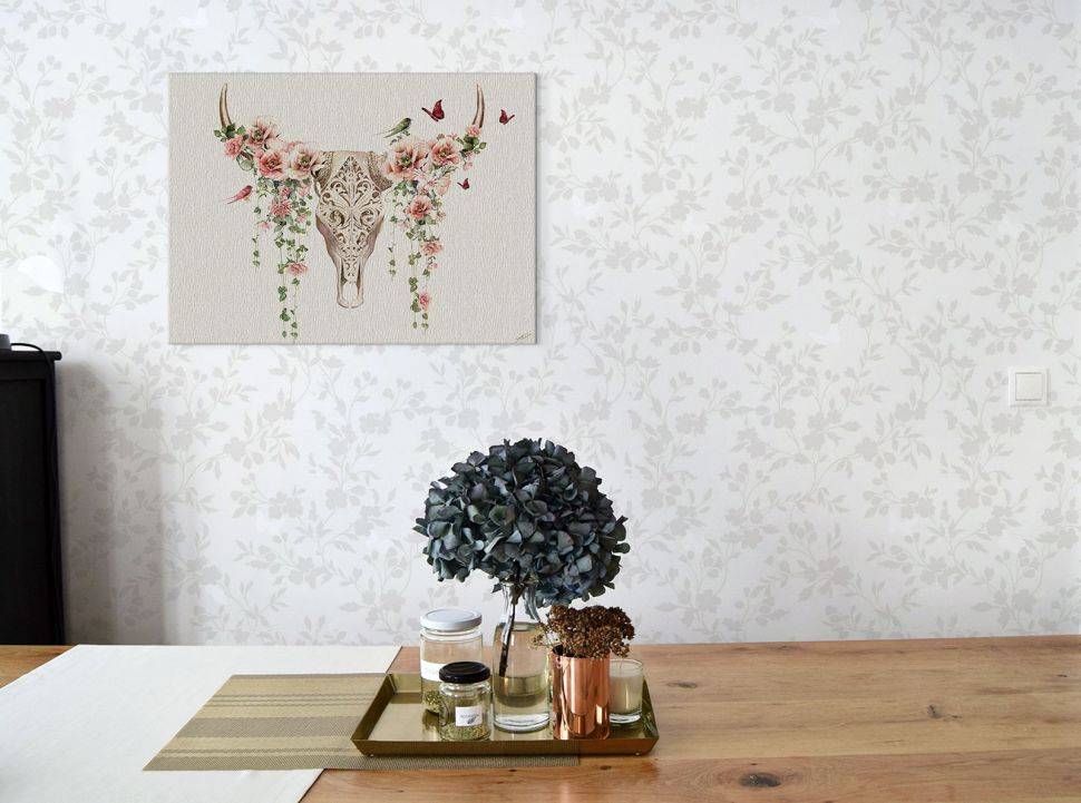 Ciekawy obraz na płótnie przedstawiający czaszkę z różami powieszony nad drewnianym stołem