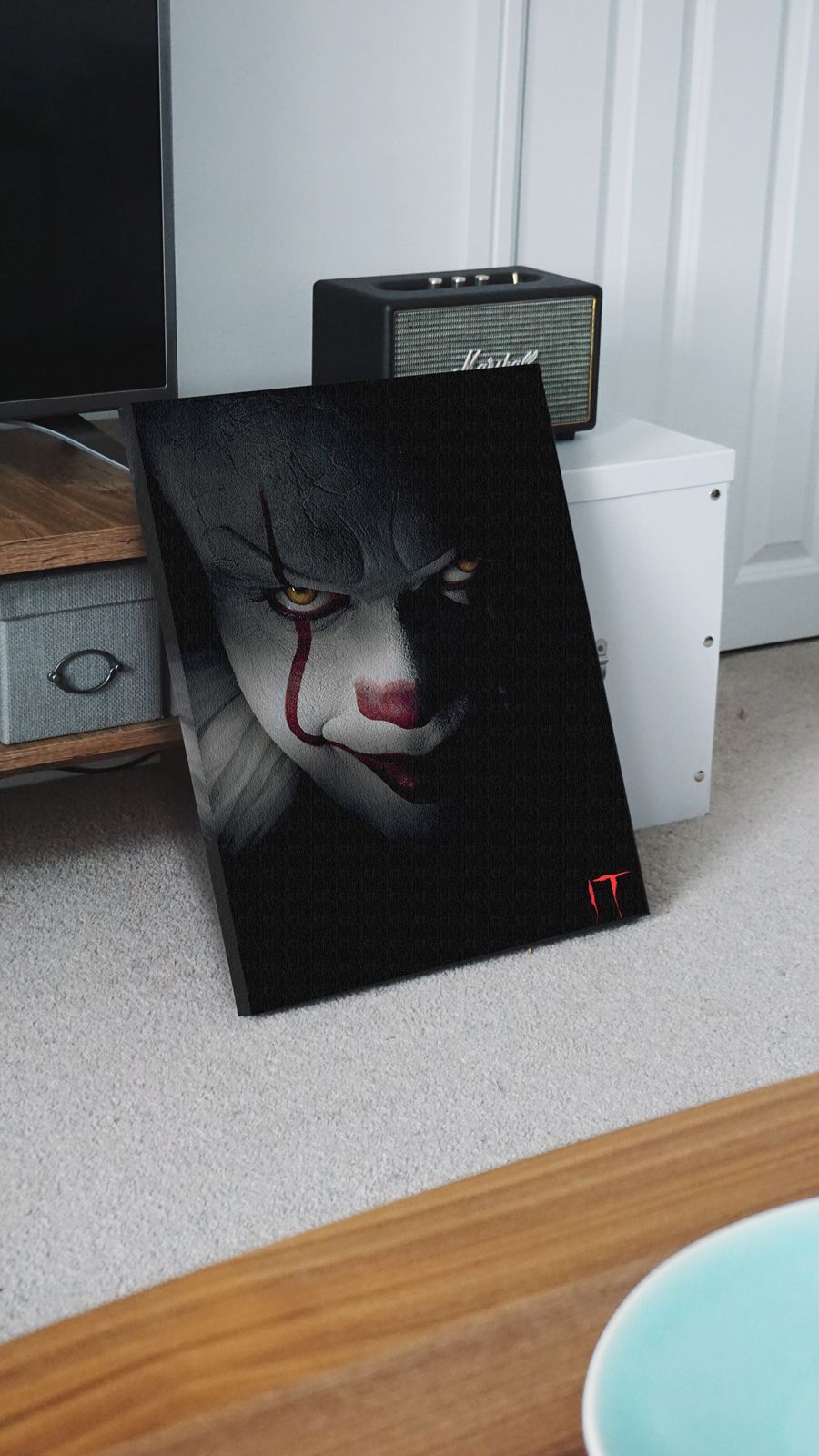 Obraz na płótnie z horroru It postawiony w salonie na podłodze, oparty o szafkę telewizyjną