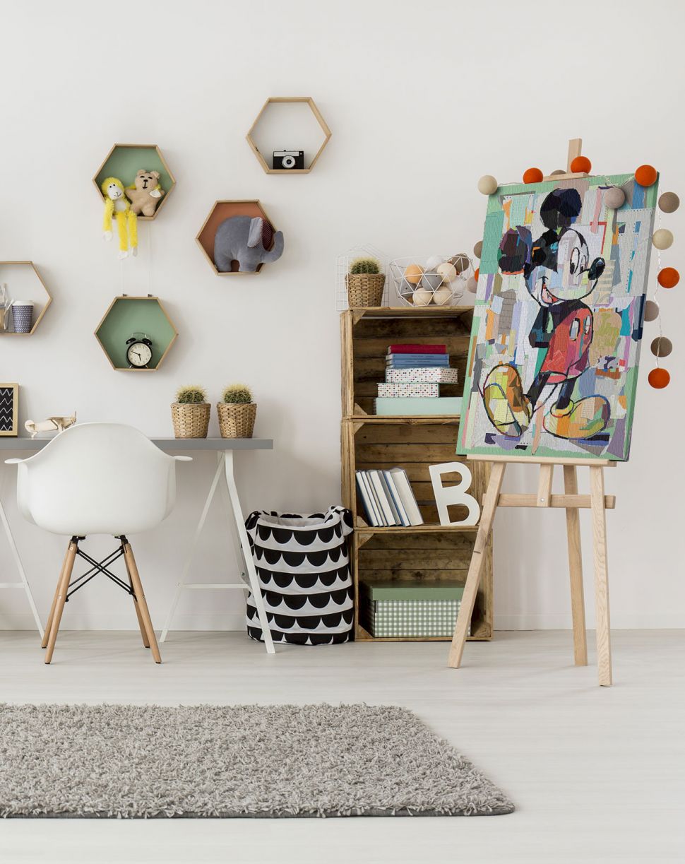 Canvas z Myszką Miki postawionym na drewnianej sztaludze w dziecięcym pokoju