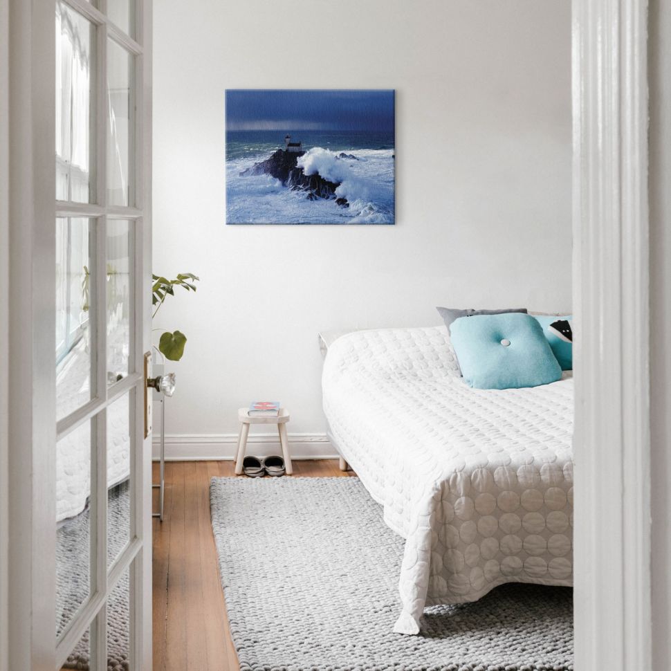 Aranżacja sypialni w której nad łóżkiem na ścianie wisi obraz przedstawiający sztorm na morzu