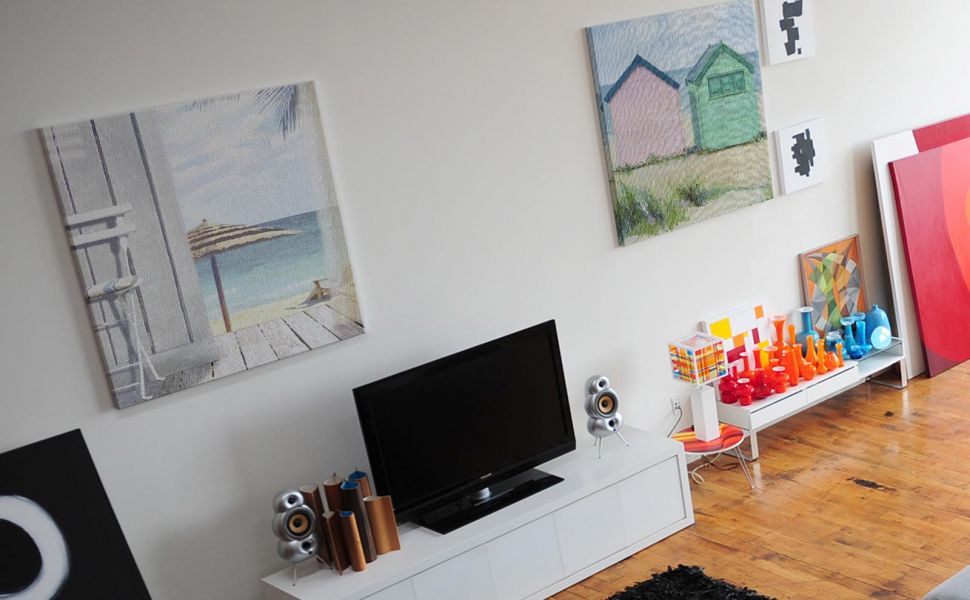 Stylowy salon z wiszącymi na ścianie obrazami na płótnie przedstawiającymi morskie widoki