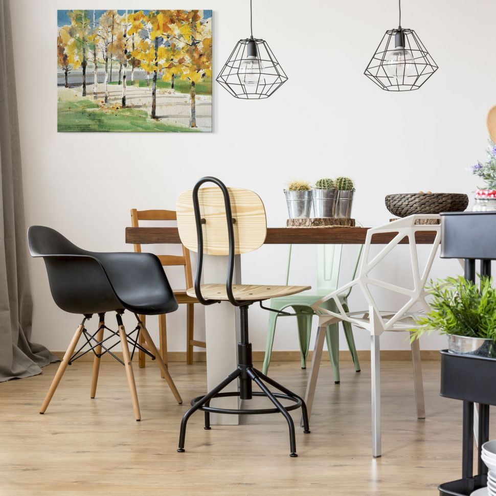 Zdjęcie pkazujące stoł kuchenny z krzesłami nad którym wisi obraz na płótnie przedstawiający parkową alejkę z brzozami