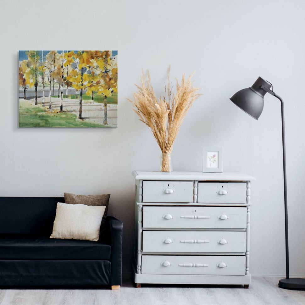 Piękna brzozowa aleja jesienną porą na obrazie na płótnie powieszonym a salonie nad czarną sofą obok białej komody z szufladami