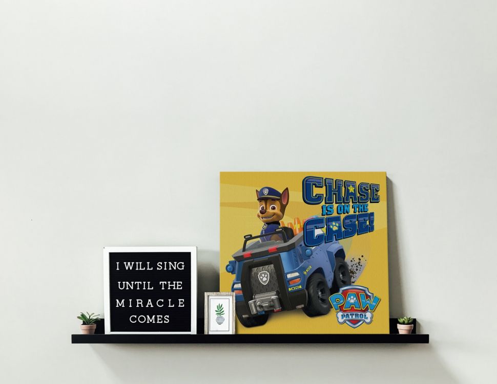 Obraz na płótnie oparty o ścianę postawiony na półce przedstawiający Chase z bajki Psi Patrol