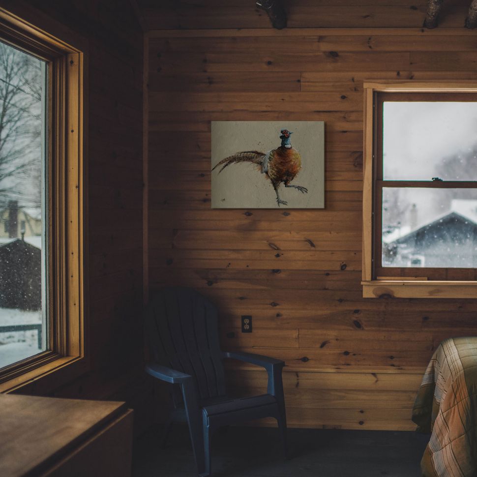 Obraz na płótnie przedstawiający bażanta wiszący w klimatycznym górskim domku na ścianie z drewna