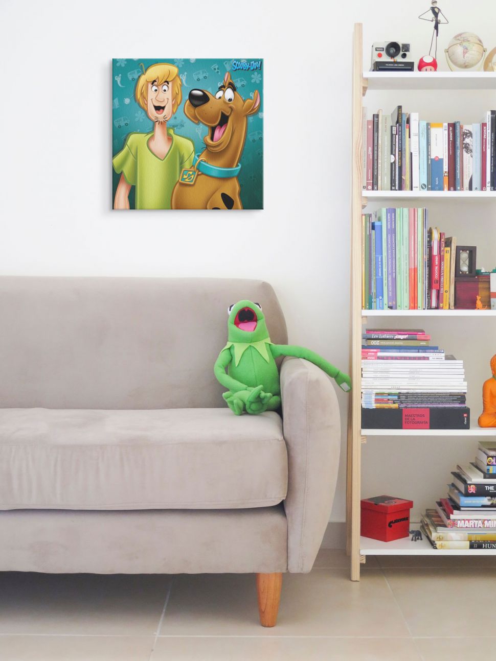 Obraz na płótnie przedstawiający Scooby Doo i Kudłatego wiszący nad kanapą obok regału z książkami