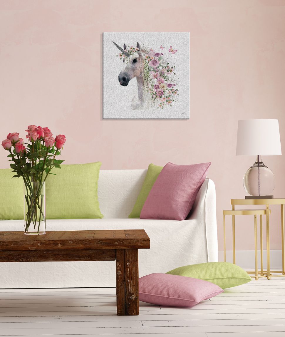 Obraz na płótnie przedstawiający jednorożca z grzywą w kwiaty powieszony w salonie na różowej ścianie