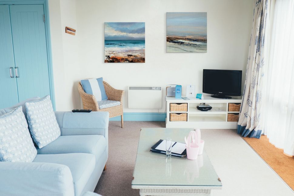 Canvasy autorstwa Joanne Last przedstawiające ocean i plaże wiszące w salonie na białej ścianie