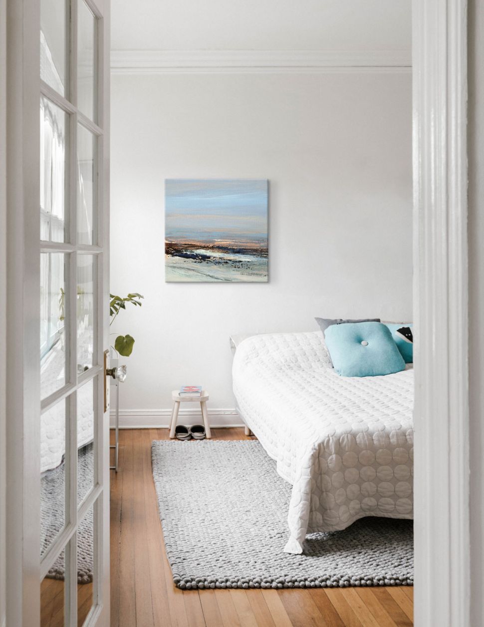 Obraz na płótnie z nadmorskim pejzażem wiszący w jasnej sypialni na białej ścianie