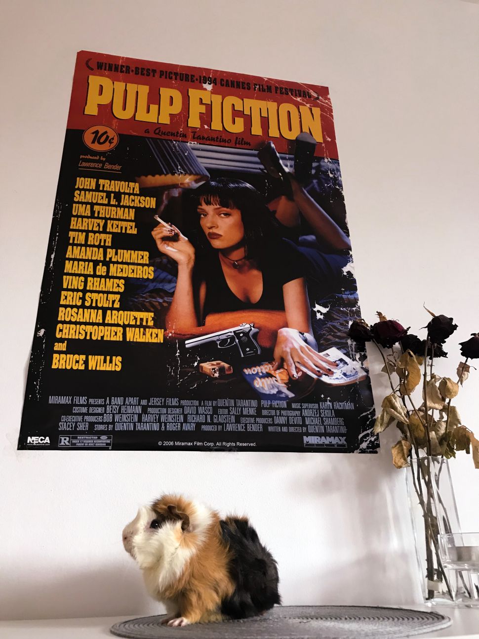 Plakat z filmu Pulp Fiction powieszony na białej ścianie