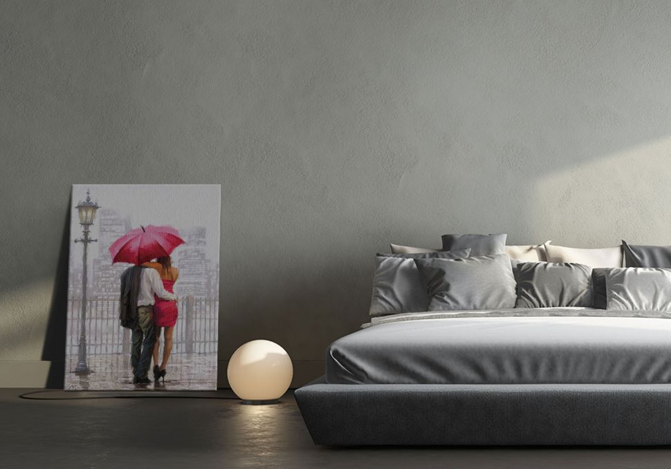 Obraz na płótnie przedstawiający parę pod parasolem postawiony na podłodze w salonie obok łózka i lampki nocnej
