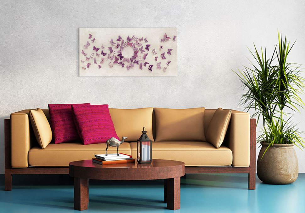 Canvas z fioletowymi motylkami na białym tle powieszony w salonie nad kanapą