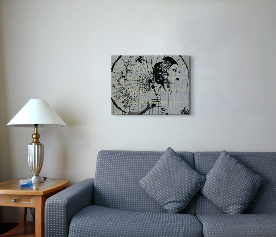 Obraz na płótnie autorstwa Loui Jover powieszony nad szarą kanapą w salonie obok stolika z lampką