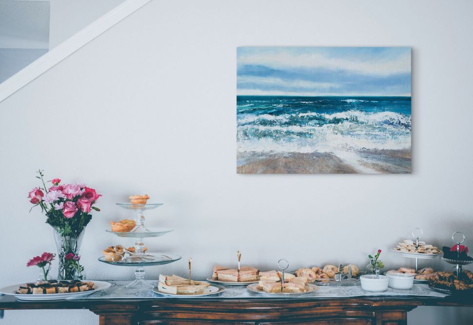 Obraz na płótnie przedstawiający ocean powieszony nad drewnianym stołem