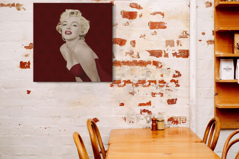 Canvas z wizerunkiem Marylin Monroe powieszony w restauracji na ceglanej ścianie