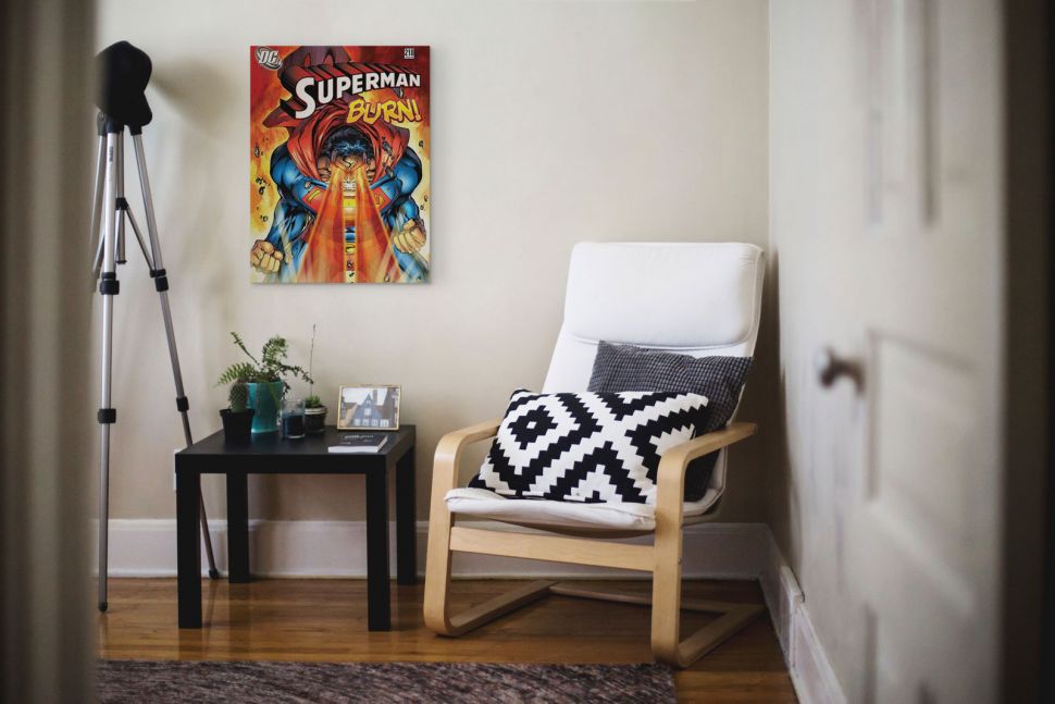 Obraz na płótnie przedstawiający Supermana powieszony w pokoju nad czarną ławą