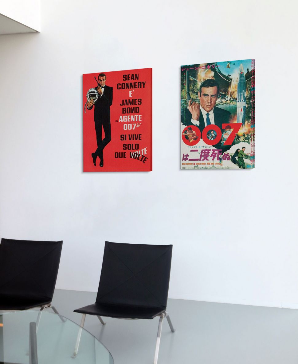 Obrazy filmowe powieszone na ścianie w korytarzu nad czarnymi krzesłami
