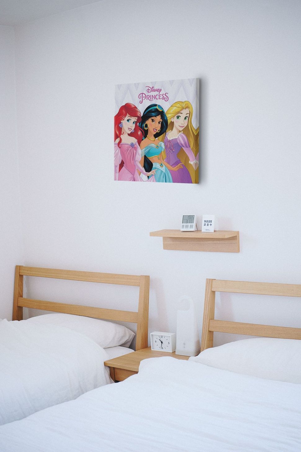 Obraz na płótnie przedstawiający księżniczki Disneya powieszony w pokoju nad łóżkami
