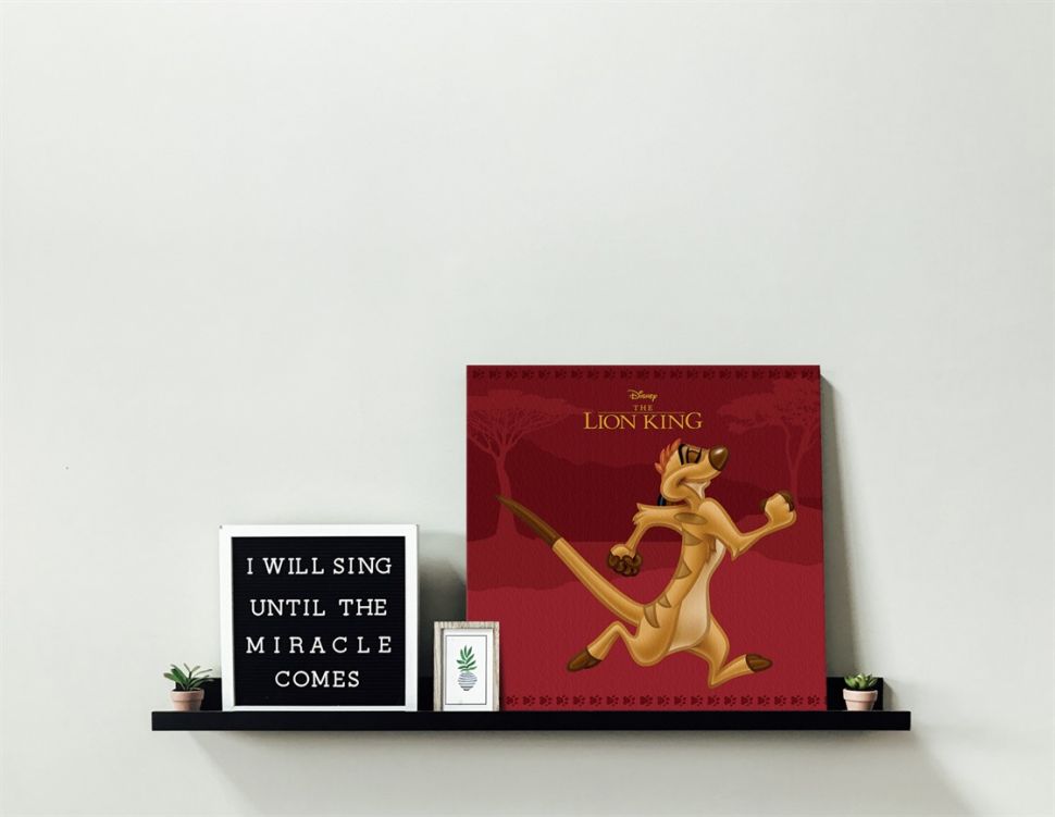 Obraz z filmu Król Lew z wizerunkiem Timona umieszczony na półce w salonie