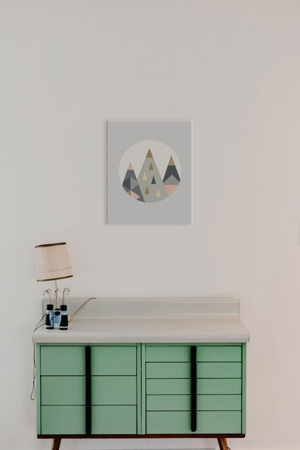 Canvas Trójkątne góry powieszony w pokoju nad zieloną szafką z nocną lampką