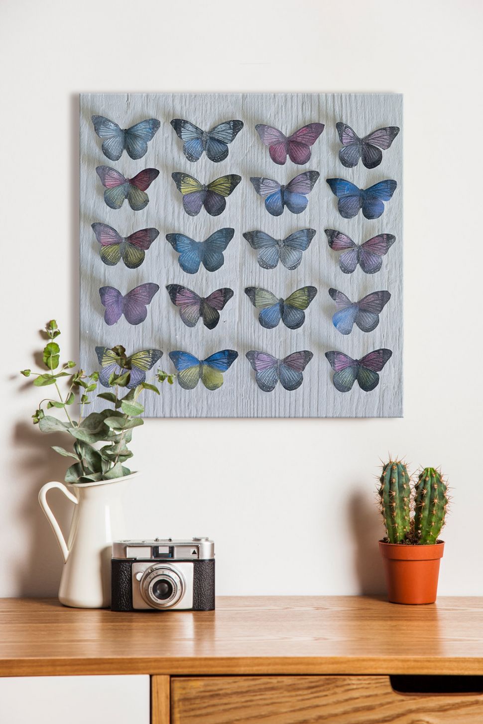 Canvas autorstwa Howarda Shootera pod tytułem Kolekcja motyli zawieszony w pokoju dziennym nad szafką z kwiatkami