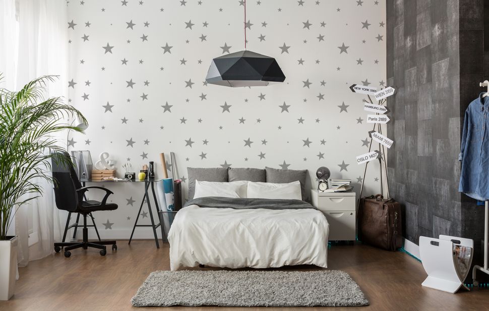 Tapeta w szare gwiazdki umieszczona na ścianie w sypialni
