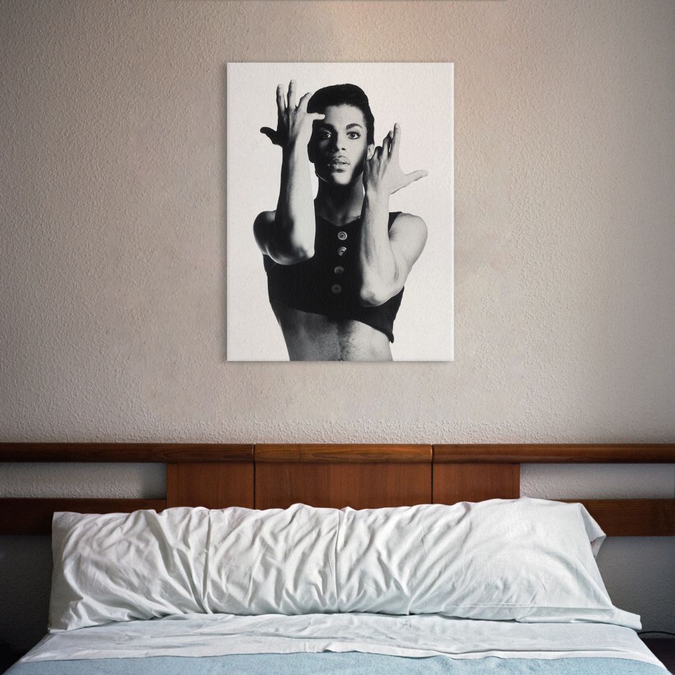 Obraz z albumu Prince'a Parade powieszony w sypialni nad dużym łóżkiem z białą pościelą