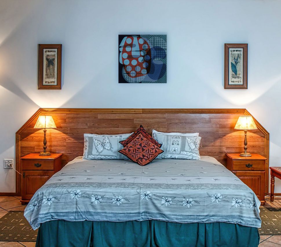 Niebieski abstrakcyjny obraz na płótnie powieszony w sypialni nad drewnianym łóżkiem